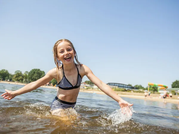 Girl swims in natural pool at Roan Luxury Camping De Schatberg.