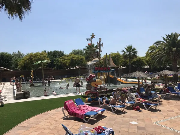 Sunbeds by the pool and water playground at Roan camping La Masia.