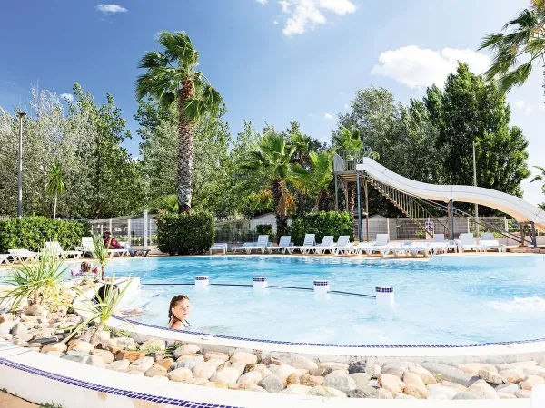 Beautifully landscaped pool with waterslide at Roan camping Les Sablines.