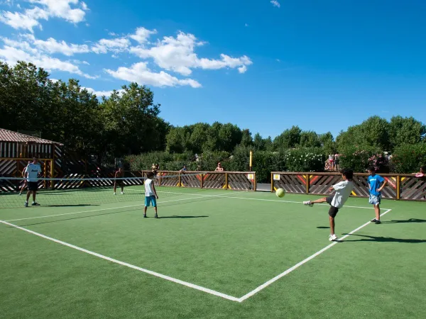 Playing soccer on multi-sport field at Roan camping Domaine de La Yole.