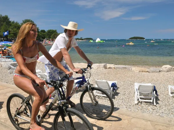 Cycling along the pebble beach at Roan camping Valkanela.