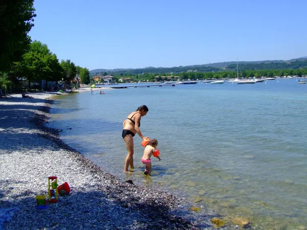 Mother with baby in the lake at Roan camping La Rocca Manerba.