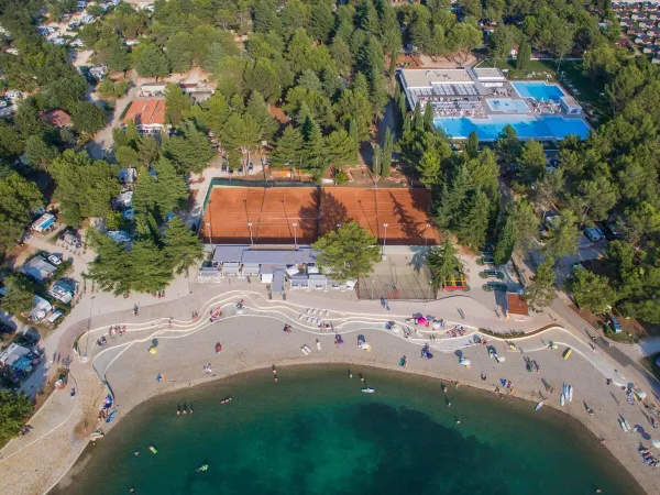 Aerial view of pebble beach and beach bar at Roan camping Valkanela.