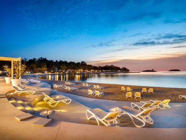 Lounge plateau and pebble beach in the evening at Roan camping Valkanela.