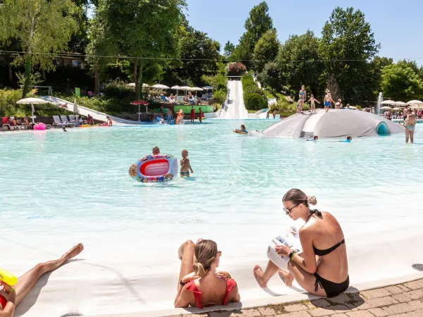 Parents and children enjoy lagoon pool at Roan camping Altomincio.