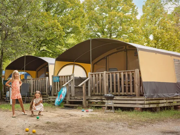Children play in front of the Holiday Lodgetent at Roan camping La Rocca Manerba.