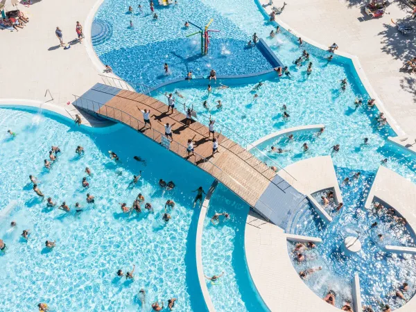 Lively drone shot of the swimming pool at Roan camping Adriano Village.