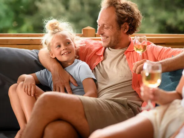 Family relaxing on the lounge sofa at Roan Camping Butterfly.