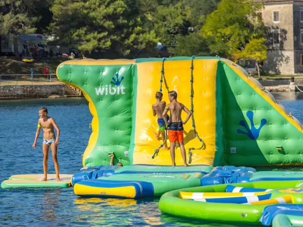 Fun on the water playground in the sea at Roan camping Lanterna.