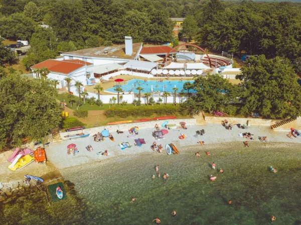 Overview pebble beach and swimming pool at Roan camping Bijela Uvala.