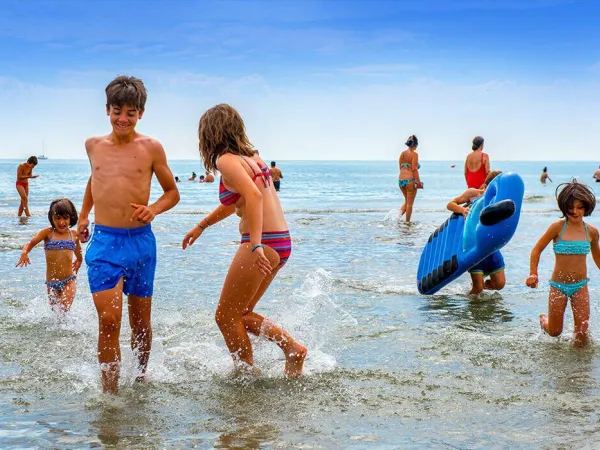 Children play in the sea at Roan camping Sole Family Camping Village.