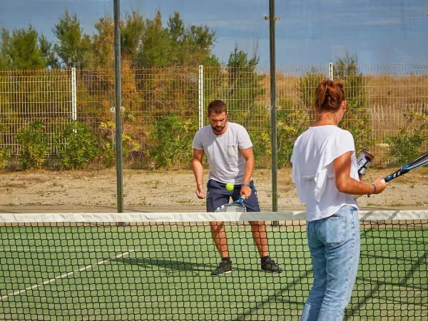 2 people play a game of tennis at Roan camping Les Dunes.