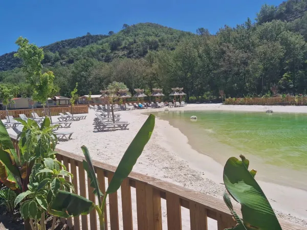 Lagoon pool with sandy beach and sunbeds at Roan campsite Verdon Parc.