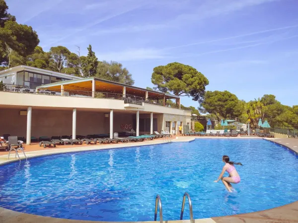 Girl takes a jump in the pool at Roan campsite Internacional de Calonge.