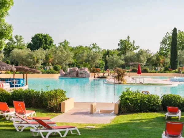 Grassy meadow with swimming pool and pool bar at Roan camping Le Capanne.