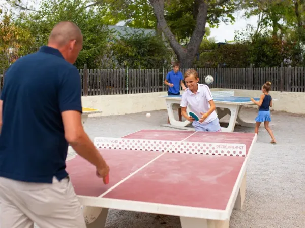 Father and son play table tennis at Roan campsite Domaine de la Noguière.