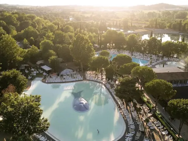 Overview of swimming pools with green surroundings at Roan camping hu Altomincio village.
