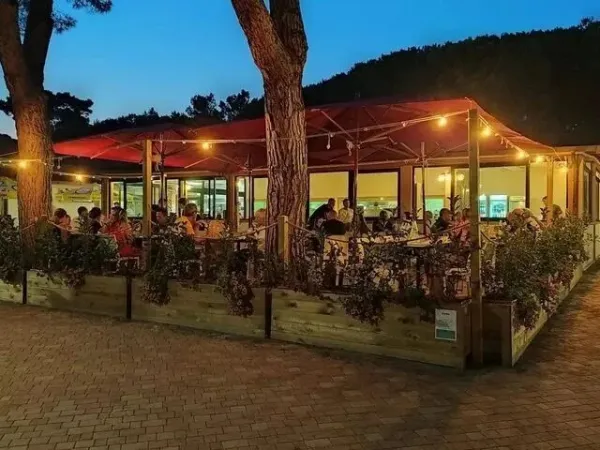 Full restaurant at night at Roan camping Del Forte.