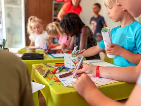 Children drawing at the Kids Club at Roan camping Château de Fonrives.