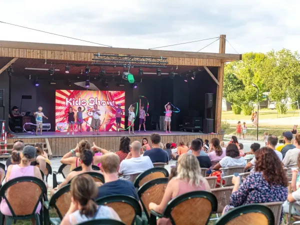 Evening disco for children on stage at Roan camping Château de Fonrives.