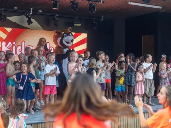 Cheerfully singing children on stage at Roan camping Château de Fonrives.
