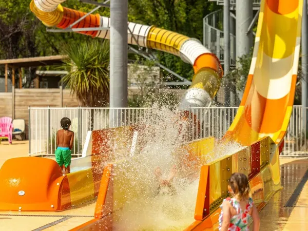 Splash with water on the waterslide at Roan camping Château de Fonrives.