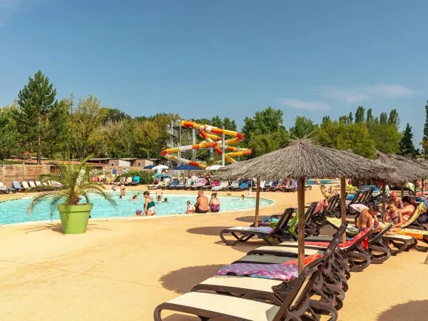 Sun loungers by the pool at Roan camping Château de Fonrives.