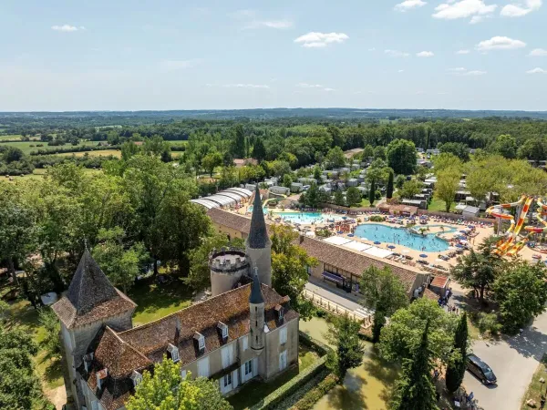Overview water park with castle at Roan camping Château de Fonrives.