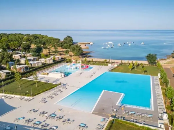 Swimming pool with children's pool and slides and bay at Roan campsite Park Umag.