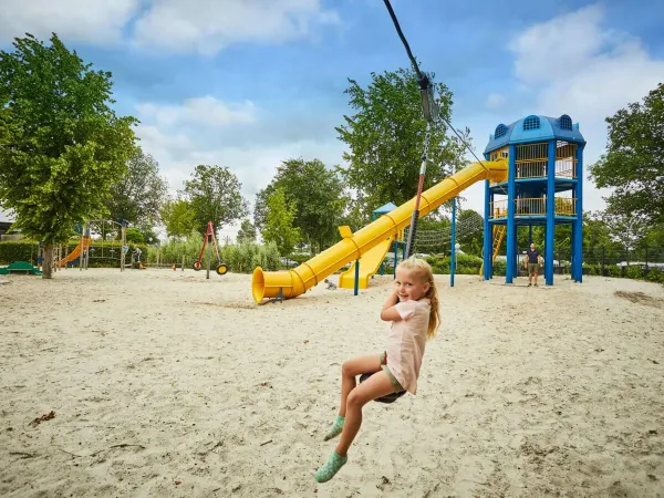 Girl on the cable car in the large playground at Roan camping Terspegelt.