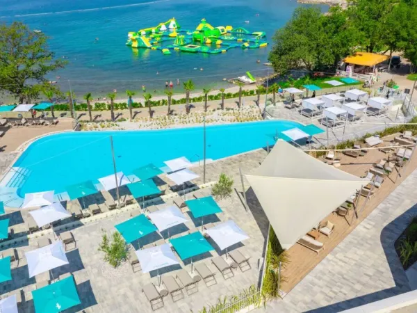 Overview pebble beach and swimming pool at Roan camping Bijela Uvala.