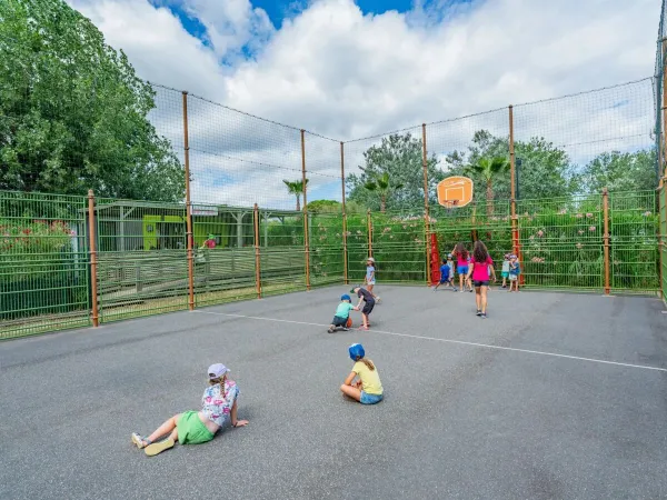 Children play on the multi-purpose sports field at Roan campsite Les Méditerranées Beach Garden.