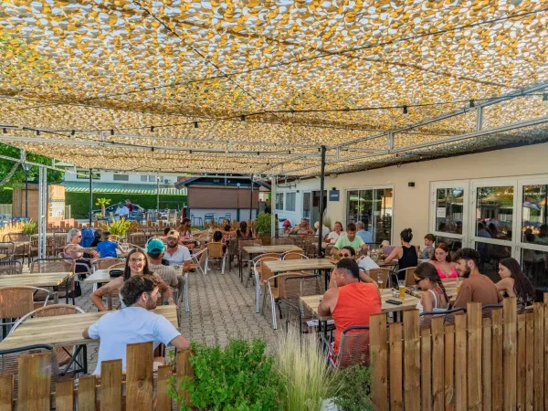 A pleasantly full terrace at Roan camping Château de Galaure.