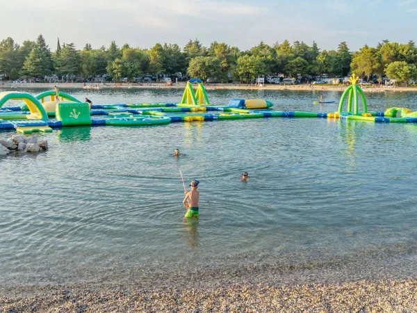 Sea with play and bouncy castles in the water at Roan camping Valkanela.