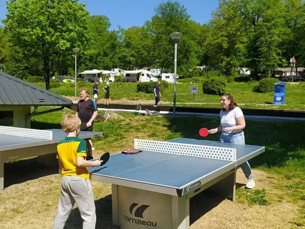 Family plays table tennis at Roan campsite Le Lac des Vieilles Forges.