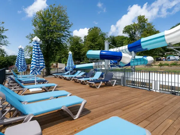 A sun terrace and slide at Roan camping Le Lac des Vieilles Forges.