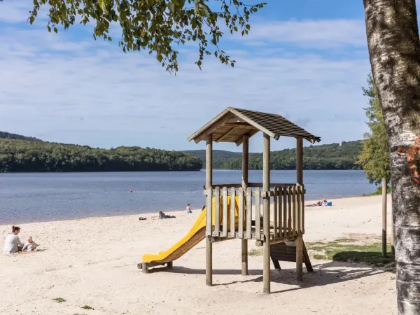 Small playground on the sandy beach at Roan camping Le Lac des Vieilles Forges.
