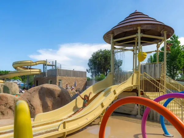Girl slides down the children's slide at Roan campsite Arinella Bianca.