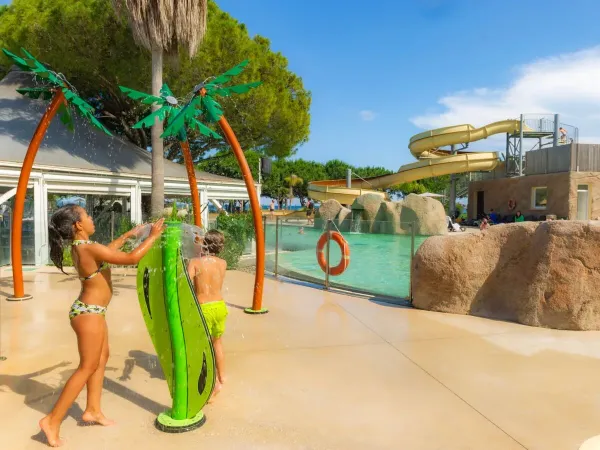 Children have fun at the water sprinklers at Roan campsite Arinella Bianca.