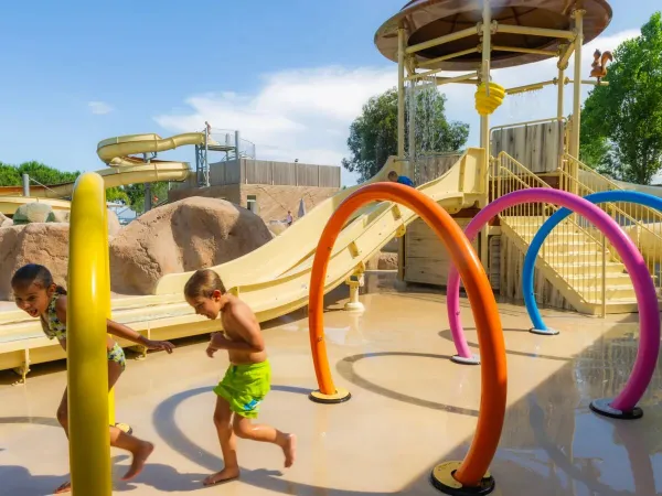 Children run through the water sprinklers at Roan campsite Arinella Bianca.