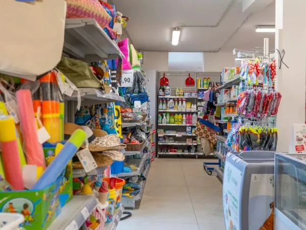 Shelves in the supermarket with beach supplies and toys at Vigna sul Mar campsite.