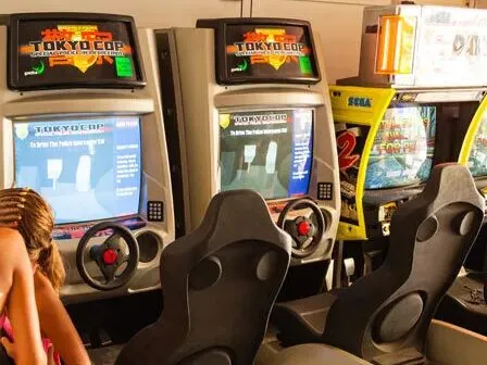 Arcade hall with racing game and slot machines at Vigna sul Mar campsite.