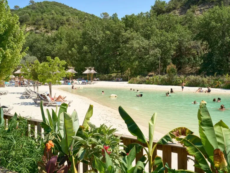 Lagoon pool with sandy beach and sunbeds at Roan campsite Verdon Parc.