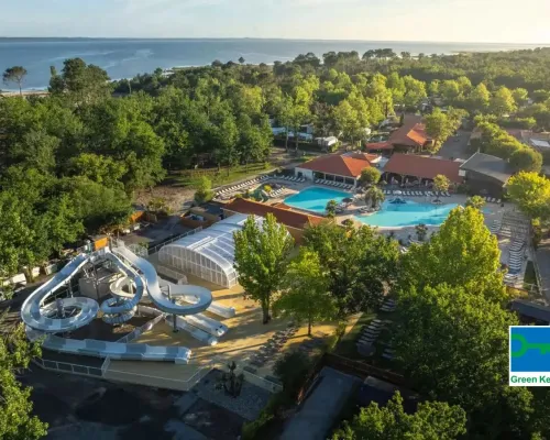 Overview of pool with slide and the sea in the distance at Roan camping Mayotte Vacances.