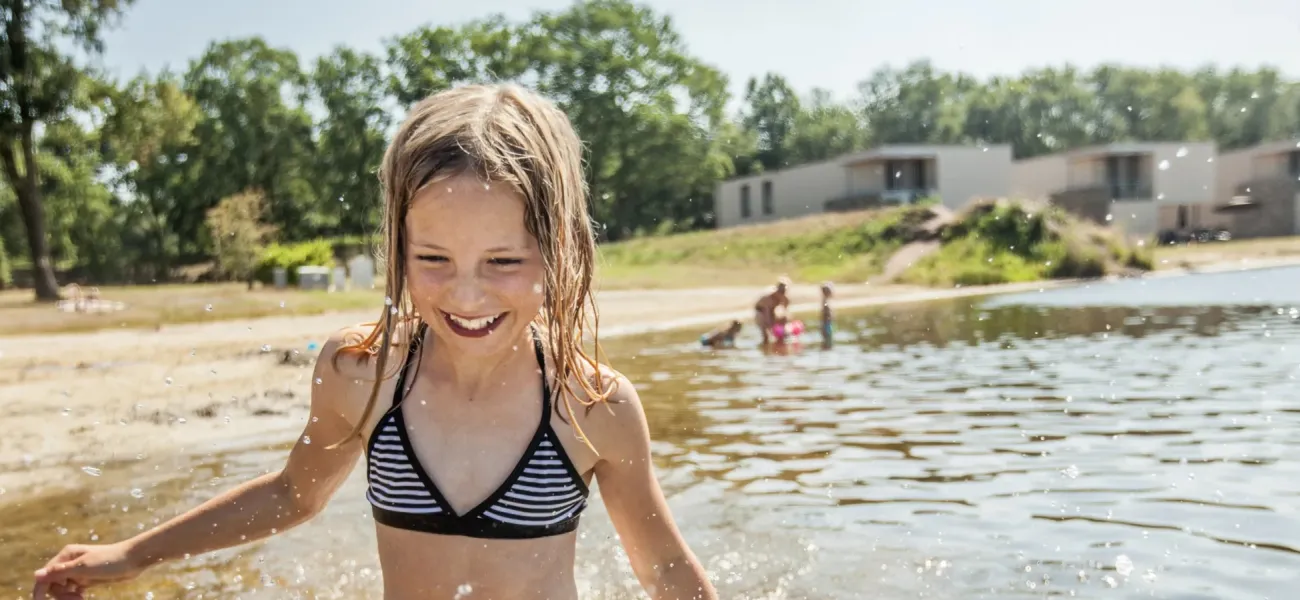 Girl laughing in a lake in Limburg.