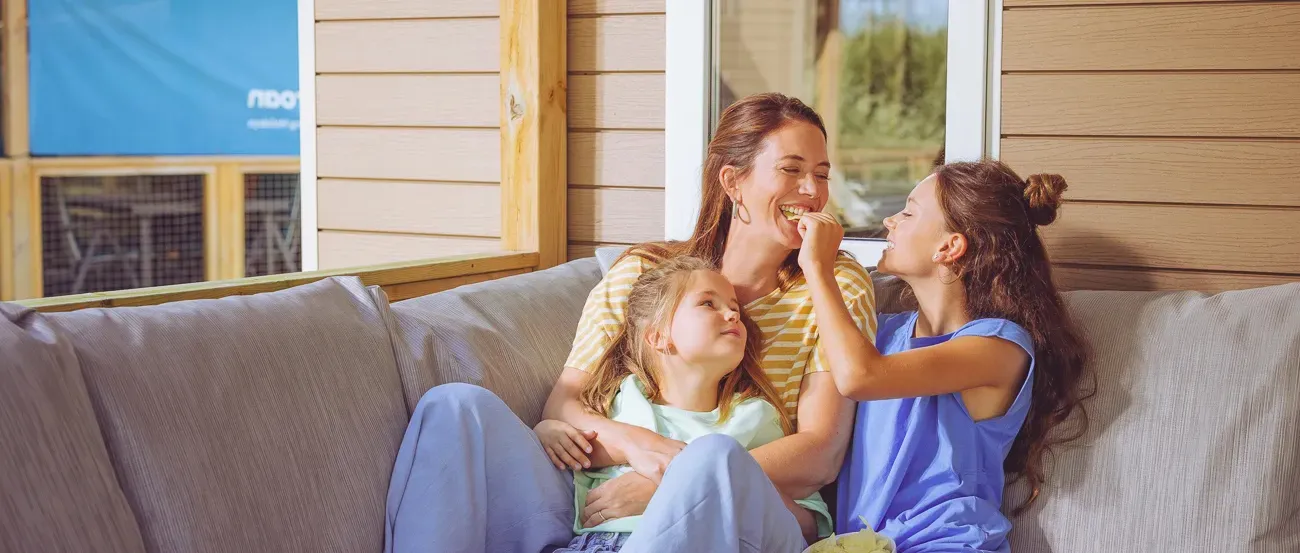 Woman lies reading a book in the sun at a Roan mobile home.